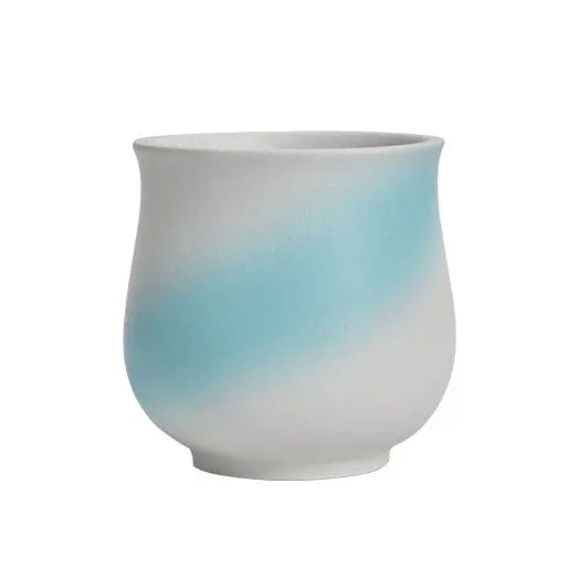 Ceramic cup with gradient blue to white color on a white background